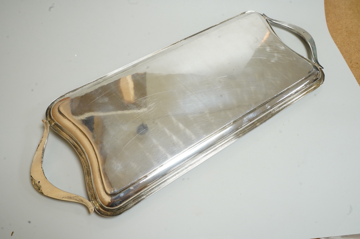 A George V silver sauceboat by Mappin & Webb, Birmingham, 1933, length 16.2cm, together with a silver salt and spoon, with blue glass liner, a silver pepperette, a pair of silver sugar tongs and a Spanish white metal two